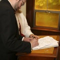 Ken signs the marriage license with birdseed in his hair